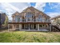 Beautiful backyard view featuring a large deck and well-maintained lawn perfect for outdoor entertainment and relaxation at 11065 W Rockland Dr, Littleton, CO 80127
