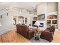 Elegant living room with a soaring ceiling, hardwood floors, fireplace, and an open view of the second story at 11065 W Rockland Dr, Littleton, CO 80127