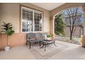 Cozy covered patio with seating, potted plant, and neutral finishes to create a welcoming outdoor space at 11065 W Rockland Dr, Littleton, CO 80127