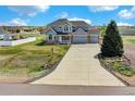 Expansive view of a lovely two-story home showcasing a long driveway and well-maintained lawn at 16680 Stroilway St, Hudson, CO 80642
