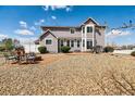 Large backyard with stone landscaping, patio, and seating area ideal for entertaining at 16680 Stroilway St, Hudson, CO 80642
