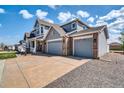 Charming two-story home boasts a three-car garage and inviting front porch with beautiful stone accents at 16680 Stroilway St, Hudson, CO 80642