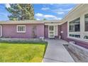 Close-up of the house's front entrance with a well-kept lawn at 1830 Zang St, Golden, CO 80401