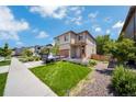 Well-kept home featuring a lush green lawn, landscaped flower bed, and a two car garage at 502 Ledge St, Brighton, CO 80603