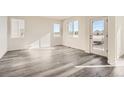 Bright and airy living room featuring gray vinyl plank flooring and a door leading to the outside at 1236 S Algonquian St, Aurora, CO 80018