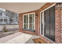 Inviting front porch with brick accents and a secure-looking black front door at 7157 S Niagara Ct, Centennial, CO 80112