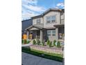 Inviting townhome showcasing a covered porch with decorative plants, neutral siding, and stone landscaping at 28330 E 6Th Pl, Watkins, CO 80137