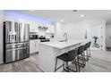 Contemporary kitchen featuring a large island with bar stools, stainless appliances, and white subway tile at 28330 E 6Th Pl, Watkins, CO 80137