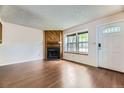 Inviting living room with a cozy fireplace, wood flooring, and ample natural light at 4130 E 94Th Ave # B, Thornton, CO 80229