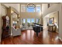 Bright living room with fireplace, piano, hardwood floors and abundant natural light from large windows at 4605 Tierra Alta Dr, Castle Rock, CO 80104