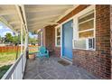 Inviting covered front porch with brick facade and a blue front door at 5008 Sherman St, Denver, CO 80216
