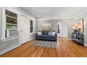 Cozy living room featuring hardwood floors, a blue sofa, and neutral wall colors at 5008 Sherman St, Denver, CO 80216