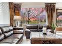 Relax in this inviting living room with views of the manicured lawn, featuring comfortable seating and elegant decor at 10061 Bluffmont Ct, Lone Tree, CO 80124