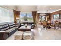 Bright living room features large windows, dark leather sofas, and stylish decor, perfect for relaxing or entertaining guests at 10061 Bluffmont Ct, Lone Tree, CO 80124