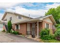 Inviting brick townhome with a covered porch, manicured bushes, and convenient parking at 9824 Lane St, Thornton, CO 80260