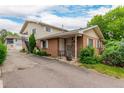 Inviting brick townhome with well-maintained landscaping, a covered porch, and convenient parking at 9824 Lane St, Thornton, CO 80260