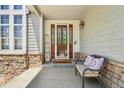 Inviting front porch with a decorative glass door, stone accents and a cozy bench seating at 10441 Carriage Club Dr, Lone Tree, CO 80124