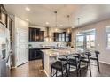 Elegant kitchen boasts granite countertops, stainless appliances, dark wood cabinets, and breakfast bar at 4406 Sidewinder Loop, Castle Rock, CO 80108