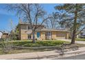 Charming two-story home with a well-maintained lawn, mature trees, and an attached garage at 12995 W Chenango Ave, Morrison, CO 80465