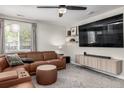Cozy living room with plush carpet, entertainment center, comfortable seating, and large windows at 12908 Hudson St, Thornton, CO 80241