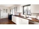 Bright kitchen with white cabinets, butcher block countertops, and stainless steel appliances at 3004 S Niagara Way, Denver, CO 80224