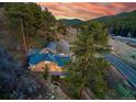 Panoramic view of mountain home and landscape with mature trees, and open space at 20951 Pleasant Park Rd, Conifer, CO 80433