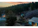 Picturesque mountain property featuring home, horse barn, and horses grazing in a tranquil setting at 20951 Pleasant Park Rd, Conifer, CO 80433