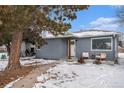 Updated gray house with snowy front yard and landscaping at 1280 Macon St, Aurora, CO 80010