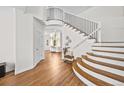 Bright foyer features wood floors, curved staircase with iron railings, and leads to a living room at 10802 W Indore Dr, Littleton, CO 80127