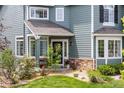 Inviting front entrance featuring a covered porch, stone accents, and manicured landscaping at 10802 W Indore Dr, Littleton, CO 80127