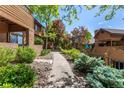 A walkway leads through meticulously maintained landscaping highlighting the property's curb appeal and serene setting at 9400 E Iliff Ave # 88, Denver, CO 80231