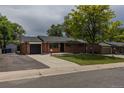 Single Gathering home featuring a dark-tone garage door and well maintained lawn at 6176 Ammons St, Arvada, CO 80004