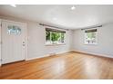 Inviting living room with gleaming hardwood floors, large windows, and a freshly painted white door at 4780 E Montana Pl, Denver, CO 80222