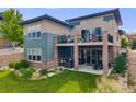 Spacious backyard featuring a patio, balcony, well-kept lawn, and inviting outdoor seating areas at 817 Backcountry Ln, Highlands Ranch, CO 80126