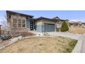 A charming, single-Gathering home with stone landscaping and a gray two-car garage and driveway at 817 Backcountry Ln, Highlands Ranch, CO 80126