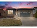 Beautiful single-Gathering home with a landscaped yard and a two-car garage. Twilight sky in the background at 817 Backcountry Ln, Highlands Ranch, CO 80126