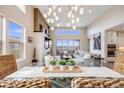 Bright, open-concept living room with high ceilings, fireplace, and large windows showcasing stunning mountain views at 817 Backcountry Ln, Highlands Ranch, CO 80126