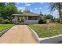Charming home exterior featuring a covered front porch and green lawn at 4001 S Acoma St, Englewood, CO 80110