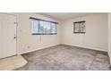 Bright living room features plush gray carpet, neutral walls, and two bright windows at 1737 Beeler St, Aurora, CO 80010