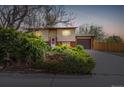 Charming home with mature landscaping, warm exterior lighting, and an attached garage, creating inviting curb appeal at 778 2Nd St, Firestone, CO 80520