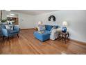 Spacious living room with hardwood floors, blue sofa and chair, and neutral decor at 805 S Everett St, Lakewood, CO 80226