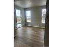 A spacious bedroom with three large windows and neutral wall color at 2277 Serenidad St, Brighton, CO 80601