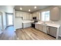 Bright kitchen with stainless steel appliances, white countertops, and wood-look flooring at 2277 Serenidad St, Brighton, CO 80601