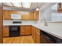 Kitchen with wooden cabinets, white countertops, and black appliances at 8563 Redstone St, Highlands Ranch, CO 80126