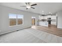 Open-concept living room with large windows, connecting to the kitchen and dining area at 2134 Alyssa St, Fort Lupton, CO 80621