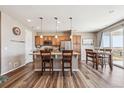 Bright kitchen featuring an island with bar seating, stainless steel appliances, and an adjacent dining area at 27319 E 10Th Dr, Aurora, CO 80018