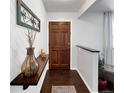 Welcoming foyer with wood-look floors, decorative shelf, and view of a wooden front door at 5747 W Elmhurst Ave, Littleton, CO 80128