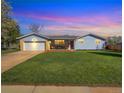 Inviting single-story home with vibrant lawn, covered porch, and garage, seen at twilight at 5747 W Elmhurst Ave, Littleton, CO 80128