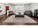 Cozy living room featuring wood-look floors, a neutral rug, and a bright front window at 5747 W Elmhurst Ave, Littleton, CO 80128