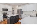 Modern kitchen with white cabinets, stainless steel appliances, black hardware, and an island at 11973 Song Bird Hills St, Parker, CO 80138